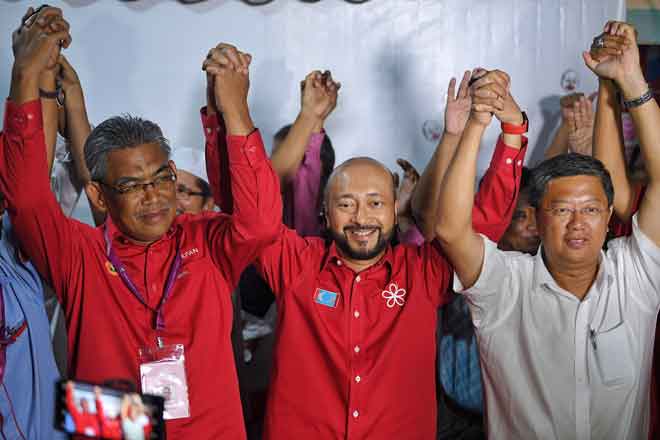   Mukhriz (tengah) mengangkat tangan bersama  Ismail (kiri) dan Tan selepas pengumuman kemenangan Pakatan Harapan bagi Pilihan Raya Umum Ke-14 di pekarangan Wisma Amanah, Bandar Stargate, Alor Setar, semalam. — Gambar Bernama