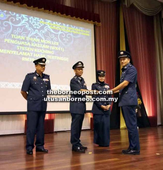  Maher (dua kiri) menyampaikan sijil penghargaan kepada Penguasa Kastam Thian Mon Lee dari Stesen Kuching dengan nilai hasil tertinggi diselamatkan disaksikan Sharifah (dua kanan). 