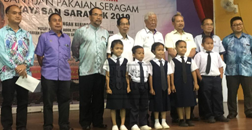 Manyin (empat kanan) merakamkan gambar bersama penerima baucer dari SK Tepoi. Turut kelihatan Timbalan Pengarah Yayasan Sarawak, Ellen Maniam Enggang (tiga kanan).