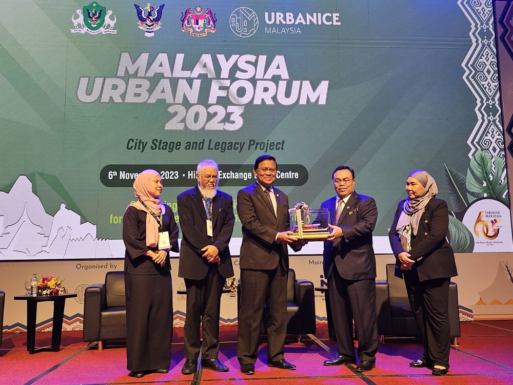 Dr Abdul Rahman menerima cenderamata berupa replika perahu tambang daripada Hilmy (dua kanan) pada Majlis Perasmian ‘City Stage and Legacy Project’ sempena Forum Bandar Malaysia Ke-5 2023 hari ini.