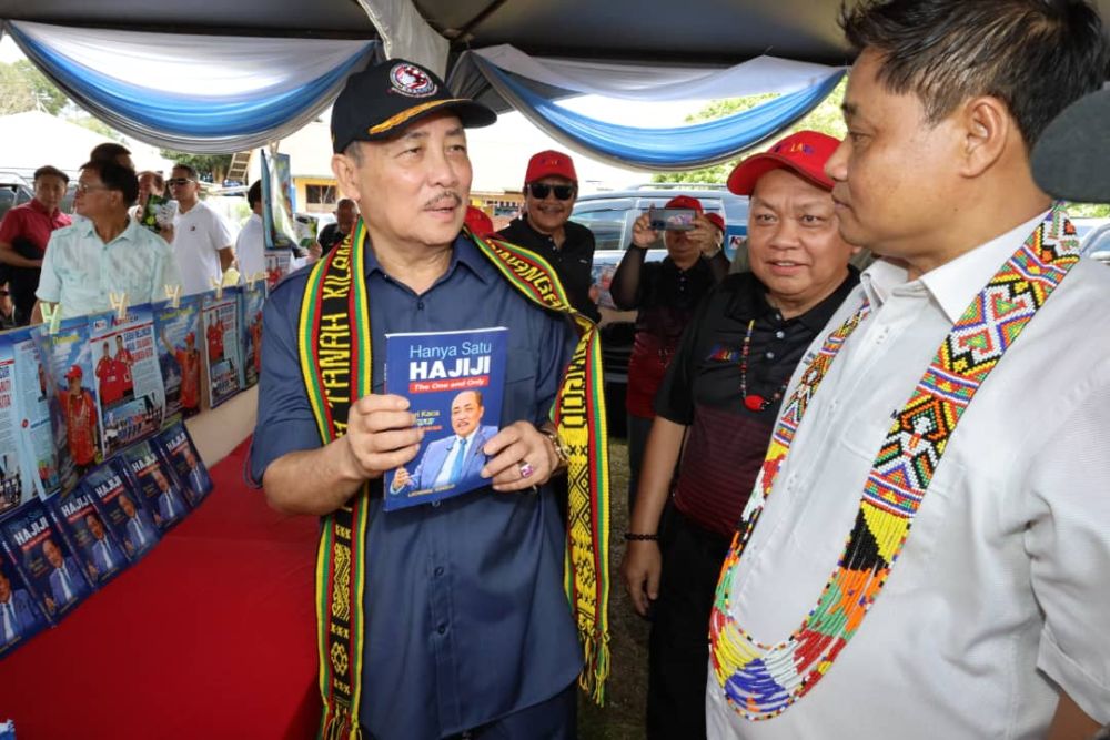  Hajiji memperkatakan sesuatu kepada Masiung (kanan) mengenai buku yang ditulis oleh Datuk Lichong Angkui (tengah) sempena majlis itu.