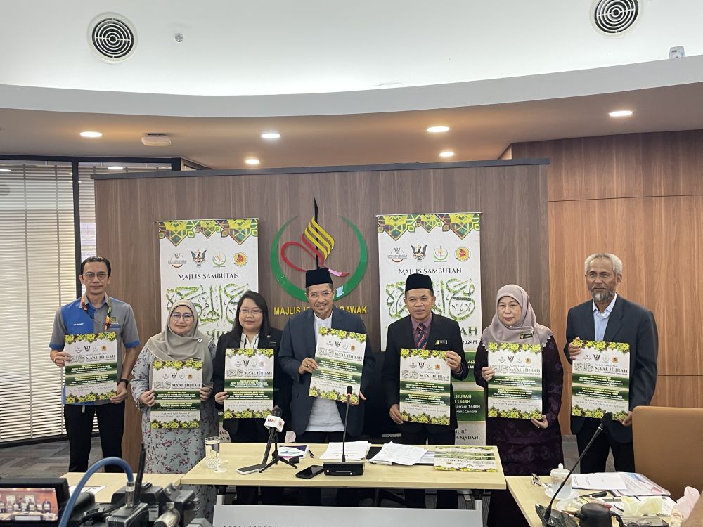 Misnu (empat kiri) bersama Mual (tiga kanan) dan yang lain menunjukkan poster Majlis Sambutan Maal Hijrah Peringkat Sarawak Tahun 1446H/2024M di pejabat MIS di Kuching, hari ini.