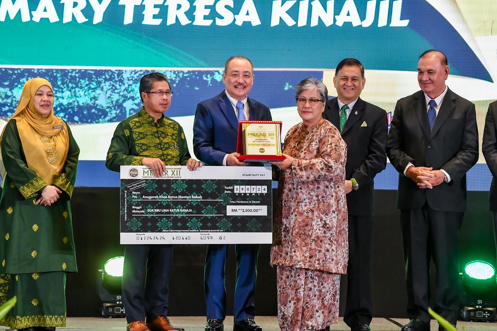  Hajiji menyampaikan Anugerah Khas Ketua Menteri kepada Datuk Mary Teresa Kinajil pada majlis berkenaan.