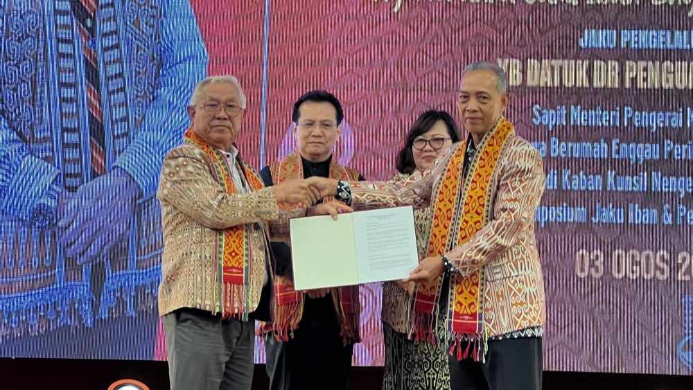 Dr Penguang (kanan) menyerahkan Resolusi Simposium Bahasa Iban dan Kraftangan 2024 kepada Sikie. 