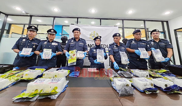  Siti Mang (tengah) menunjukkan dadah jenis syabu yang dirampas susulan penahanan dua lelaki di dua lapangan terbang di Kota Kinabalu dan Tawau.