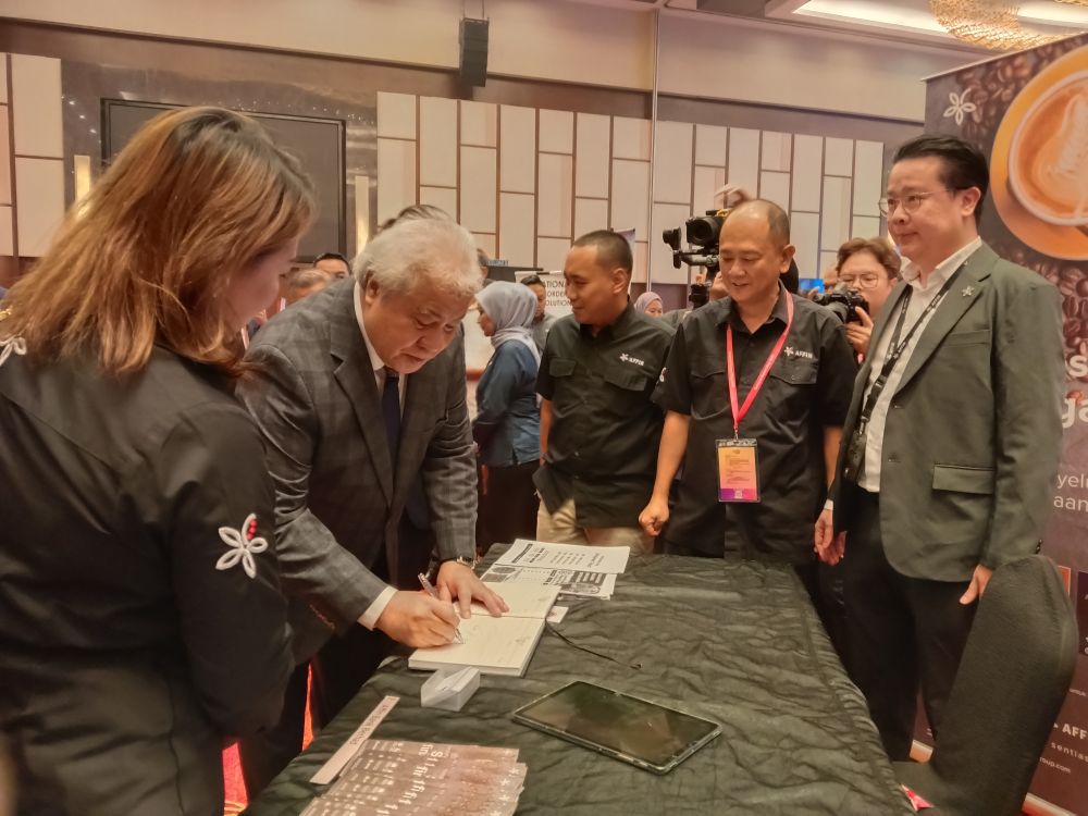 Awang Tengah menandatangani buku pelawat pada pameran sempena Hari Eksport Sarawak.