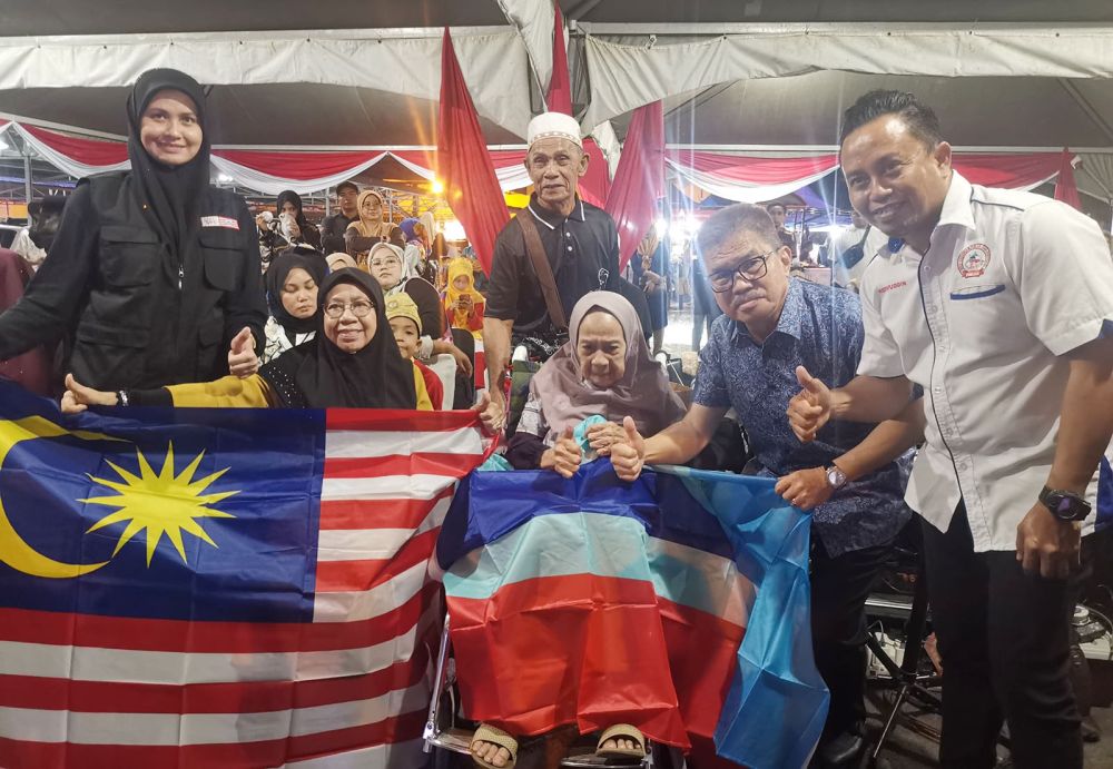  Liew menyampaikan bendera Jalur Gemilang dan Sabah kepada warga tua yang hadir dalam karnival berkenaan.