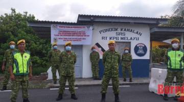 Ahadi (dua kiri) bersama anggota RELA Kampung Melayu menjaga pintu masuk kampung mereka.