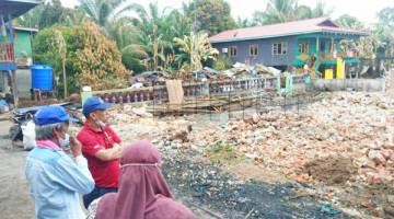 TINJAU: Mokran ditemani ketua keluarga mangsa kebakaran meninjau tapak rumah kebakaran di Kampung Kenangan Manis Batu 12.