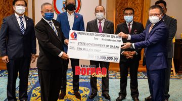 SAKSIKAN: Hajiji (tengah) menyaksikan penyerahan cek dividen bernilai RM10 juta daripada Harun (kanan) kepada Rusdin (kiri)