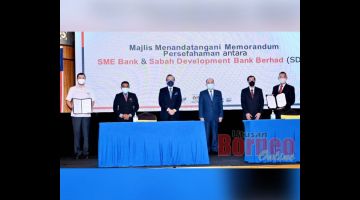 Hajiji (empat kiri) bersama Masidi, Aria (kanan) dan Vincent Pung (kanan) selepas majlis menandatangani MOU diantara SME Bank dan Sabah Development Bank.